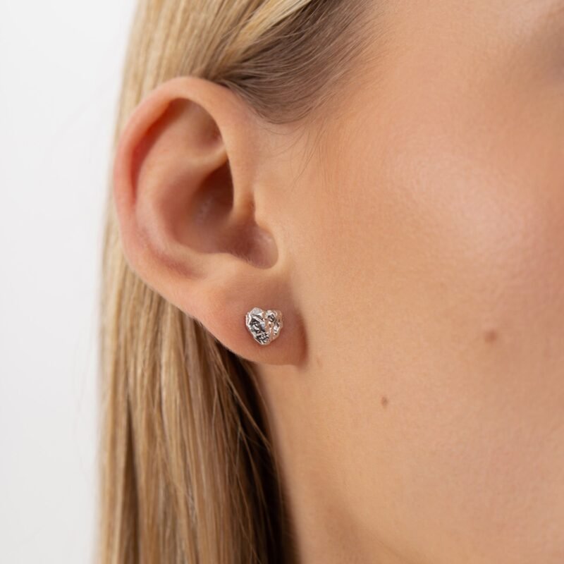 Minimalistic heart-shaped silver stud earrings.